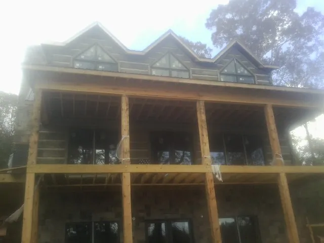 Dormers and porch framing on a large log home under construction — Roof Coating work by our crew in Springdale